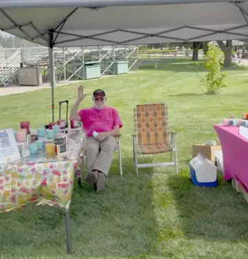 Dr. James Scapillato seated under a canopy at a community fundraising table