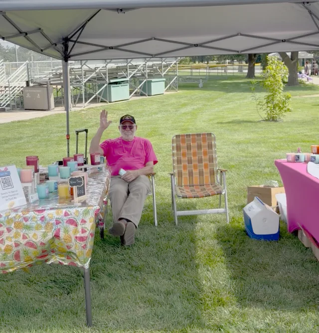 Dr. James Scapillato seated under a canopy at a community fundraising table