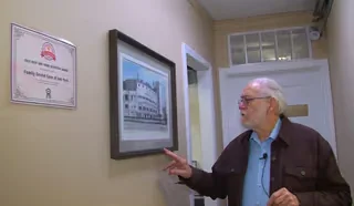 Dr. James Scapillato pointing to Chicago sports memorabilia in the office hallway