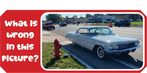 What is wrong in this picture? A classic convertible parked beside a fire hydrant